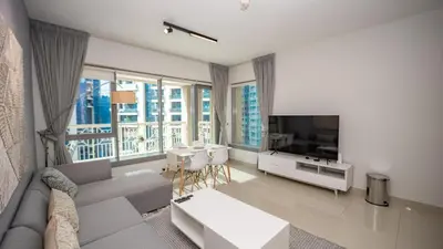 a living room with a couch and a television at Burj and fountain view 3BHK Near Dubai Mall in Dubai