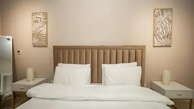a bedroom with a bed with white sheets and pillows at Burj and fountain view 3BHK Near Dubai Mall in Dubai