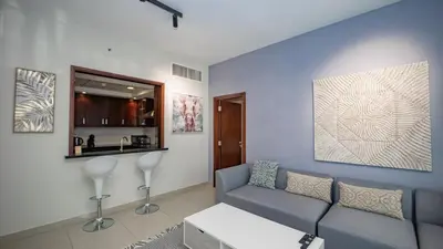 a living room with a couch and a kitchen at Burj and fountain view 3BHK Near Dubai Mall in Dubai