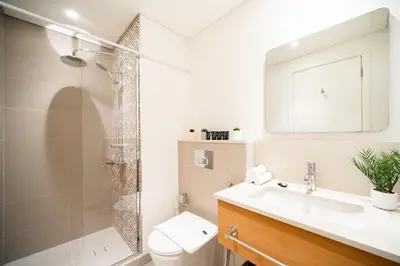 a bathroom with a shower and a sink and a toilet at SettlerHomes - Serene Golfville Escape near Parkside in Dubai