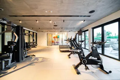 a gym with treadmills and elliptical machines at SettlerHomes - Serene Golfville Escape near Parkside in Dubai