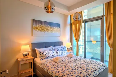 a bedroom with a bed with two lamps and a window at Business Bay Retreat in Dubai