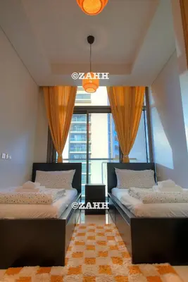 two beds in a room with a large window at Business Bay Retreat in Dubai