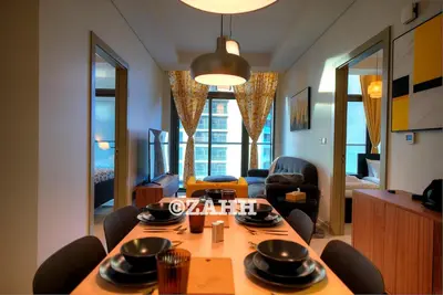 a dining room with a table and chairs and a living room at Business Bay Retreat in Dubai