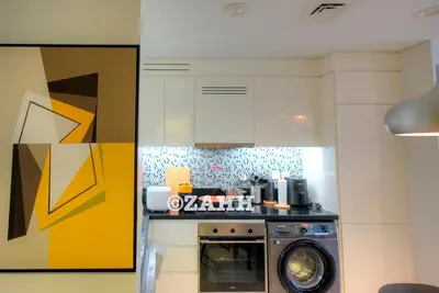 a kitchen with a stove and a washing machine at Business Bay Retreat in Dubai