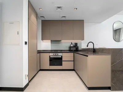 a kitchen with brown cabinets and a sink at Exceptional 1Bedroom with Premium Amenities in Dubai