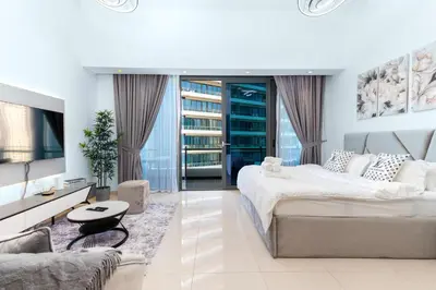 a white bedroom with two beds and a tv at Luxury Apartment in Dubai Marina w Stunning View in Dubai