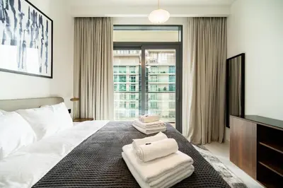 a bedroom with a bed with towels on it at SettlerHomes - Emaar Beachfront Haven With The Sea View in Dubai