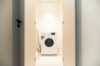 a washer and dryer in a bathroom with a washing machine at SettlerHomes - Emaar Beachfront Haven With The Sea View in Dubai