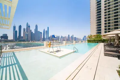 a large swimming pool with a view of a city at SettlerHomes - Emaar Beachfront Haven With The Sea View in Dubai