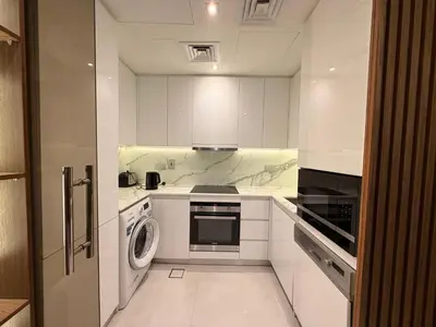 a kitchen with white cabinets and a washer and dryer at Upgraded 2 bedroom at Dubai Marina in Dubai