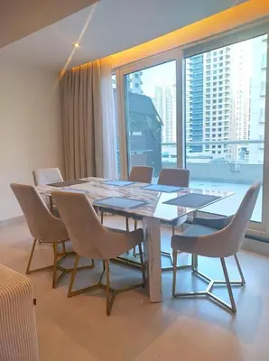 a dining room table with chairs and a large window at Upgraded 2 bedroom at Dubai Marina in Dubai