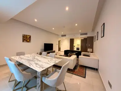 a dining room and living room with a table and chairs at Upgraded 2 bedroom at Dubai Marina in Dubai