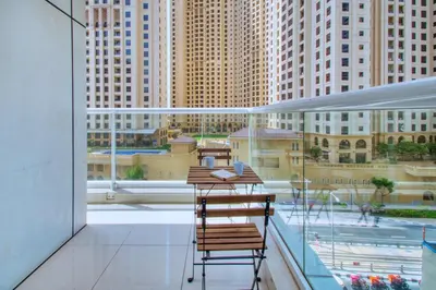 a balcony with two chairs and a table on a building at ShoresInn - Stylish Space in Dubai Marina in Dubai
