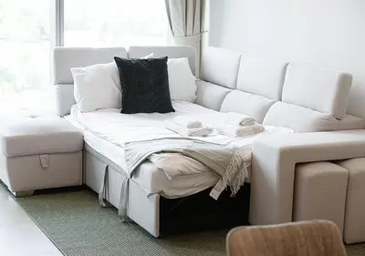 a couch and a bed in a living room at Stylish Flat in Downtown Dubai with PS5 Gym and Pool in Dubai
