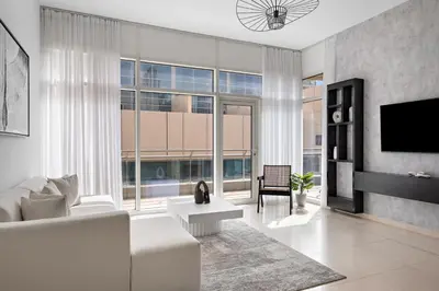 a living room with white furniture and large windows at 1BR with Study City View in Bay Square B13 in Dubai