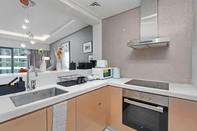 a kitchen with a sink and a stove top oven at Dubai Paramount 1BR APT Burj Khalifa view in Dubai