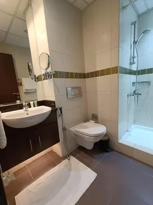 a bathroom with a sink and a toilet and a shower at Quill Residence - Canal View Spacious 3 bedroom Apartment in Dubai