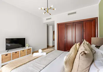 a bedroom with a large bed and a television at 5 Min Walk to Burj Khalifa 2BHK Luxury Downtown Burj Haven in Dubai