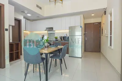 a kitchen with a table and chairs and a refrigerator at Bloomfields Modern 1bedroom In Wavez in Dubai