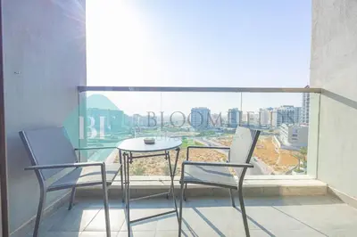 a table and chairs on a balcony with a view at Bloomfields Modern 1bedroom In Wavez in Dubai