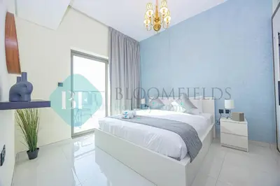a bedroom with a bed and a blue wall at Bloomfields Modern 1bedroom In Wavez in Dubai