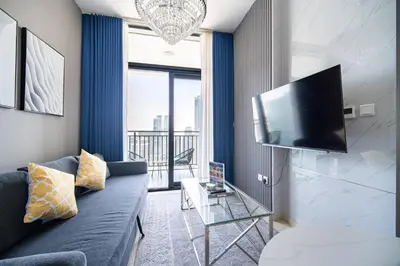 a living room with a couch and a flat screen tv at Elegant Escapes - Lavish 1B,Dubai Water Canal View in Dubai