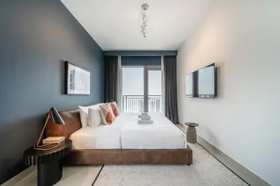 a bedroom with a bed and a large window at LUXE | Luxury 2BR | Creek View | Modern & Cozy in Dubai