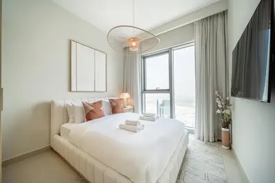 a bedroom with a large white bed and a large window at LUXE | Luxury 2BR | Creek View | Modern & Cozy in Dubai