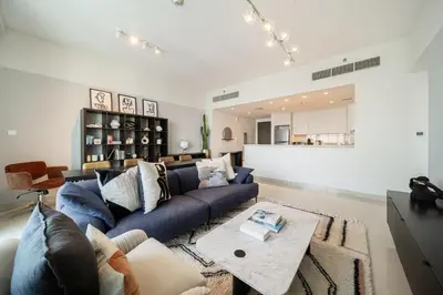 a living room with a blue couch and a table at LUXE | Luxury 2BR | Creek View | Modern & Cozy in Dubai