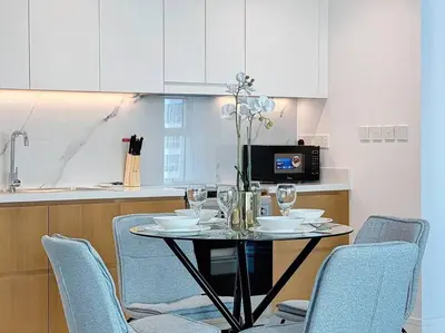 a kitchen with a table with chairs and a microwave at La Vie JBR Gorgeous One Bedroom Beach Access Panoramic Pool in Dubai