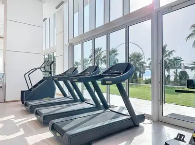 a row of treadmills in a gym with a window at La Vie JBR Gorgeous One Bedroom Beach Access Panoramic Pool in Dubai