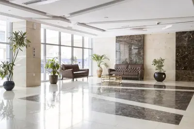 a lobby with couches and plants in a building at Luxury Studio w Marina View & New Furnishings for 4 Pax in Dubai