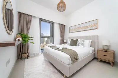 a white bedroom with a large bed and a window at Luxury High Floor Apartment with Downtown Boulevard View Opposite Dubai Mall in Dubai