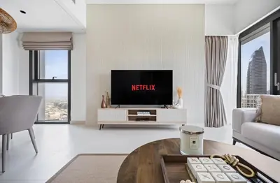 a living room with a tv and a couch at Luxury High Floor Apartment with Downtown Boulevard View Opposite Dubai Mall in Dubai
