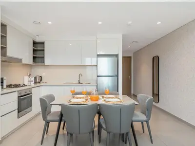 a dining room with a table and chairs in a kitchen at BRAND-NEW 1BR in DOWNTOWN I Direct DUBAI MALL Access I Balcony & Stunning Pool in Dubai