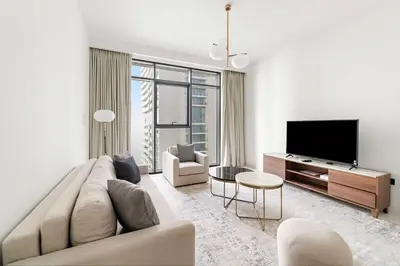 a living room with a couch and a flat screen tv at Silkhaus 1BDR in Marina Vista with Private Beach in Dubai
