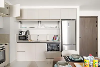a kitchen with white cabinets and a refrigerator at Silkhaus 1BDR in Marina Vista with Private Beach in Dubai