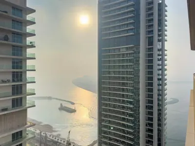 a tall building next to a body of water at Silkhaus 1BDR Marina Vista with Private Beach Access in Dubai