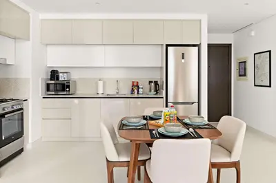 a kitchen with a table and chairs in a kitchen at Silkhaus 1BDR Marina Vista with Private Beach Access in Dubai