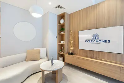a living room with a white couch and a tv at Luxe Central Marina Studio with Rooftop Pool in Dubai