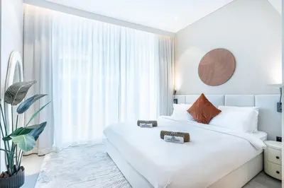 a bedroom with a white bed and a large window at Luxe Central Marina Studio with Rooftop Pool in Dubai