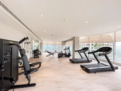 a gym with several treadmills and exercise bikes at Luxe Central Marina Studio with Rooftop Pool in Dubai