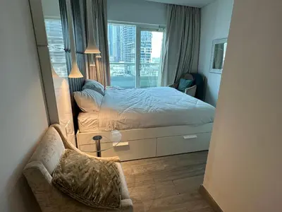 a bedroom with a bed and a large window at Damac canal views building in Dubai