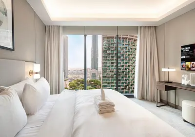 a bedroom with a white bed and a large window at Luxurious 2BR at Address Opera with Boulevard Views in Dubai