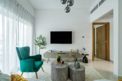 a living room with a couch and a tv on a wall at ShoresInn - Luxury 1BR with Marina View in Dubai