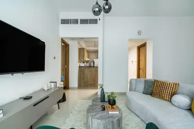 a living room with a couch and a flat screen tv at ShoresInn - Luxury 1BR with Marina View in Dubai