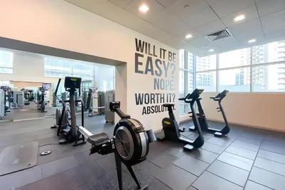 a gym with several treadmills and cardio machines at Elegant & Cozy 2BR Home in the Heart of Downtown in Dubai