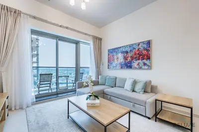 a living room with a couch and a large window at Stylish 1BR Apartment at Orchid Residence, Al Barsha South by Deluxe Holiday Homes in Dubai