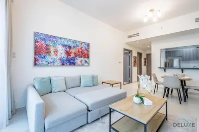 a living room with a couch and a painting on the wall at Stylish 1BR Apartment at Orchid Residence, Al Barsha South by Deluxe Holiday Homes in Dubai